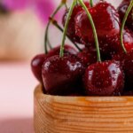 cherries-wooden-plate-with-flower-pot-close-up-pink-surface.jpg