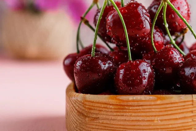 cherries-wooden-plate-with-flower-pot-close-up-pink-surface.jpg