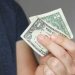 closeup-shot-person-holding-us-dollar-bill-his-hand.jpg